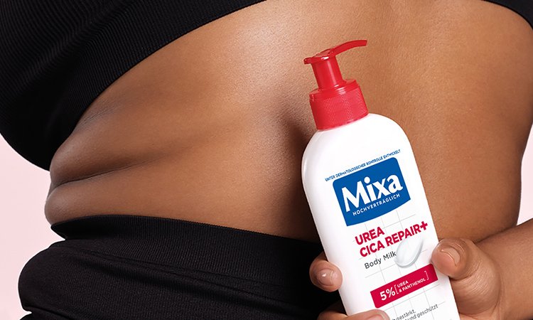 Frau hält eine Mixa Urea Cica Repair+Body Milk hinter ihrem Rücken