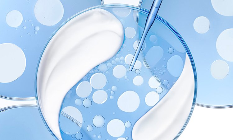 Auf einer runden Scheibe mit Creme und Serum sind feine Blasen zu erkennen