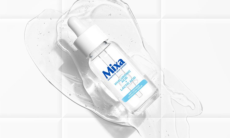 Ein kleines Fläschchen des Anti-Trockenheit Serums von Mixa liegt auf einem Klecks Serum