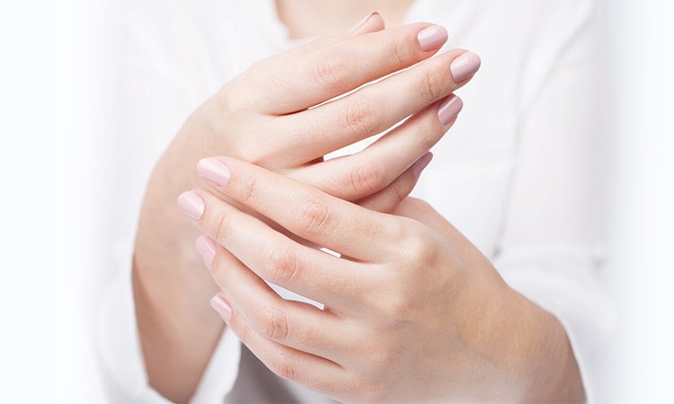 Eine Person cremt ihre Hände ein, dabei ist die Bewegung des Auftragens der Handcreme zu erkennen.