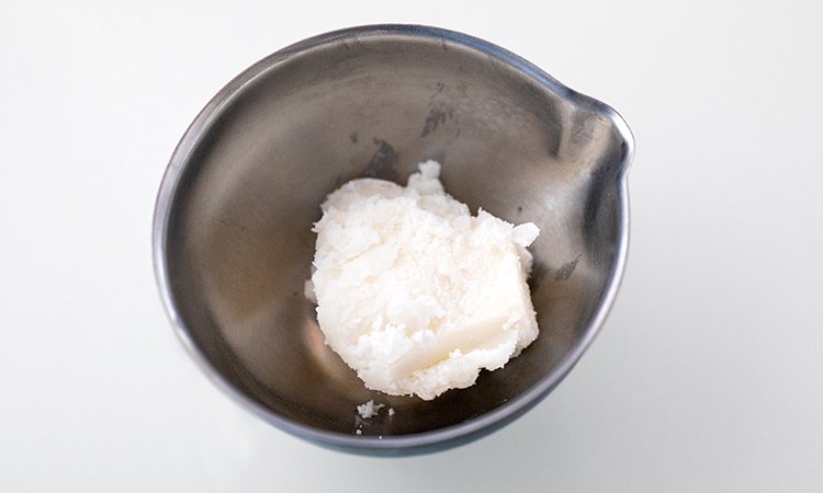 In einer kleinen silbernen Schale befindet sich etwas Sheabutter