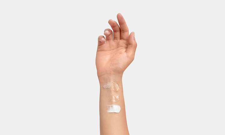 Ein Arm mit mehreren gleichmäßig verteilten Creme-Klecksen