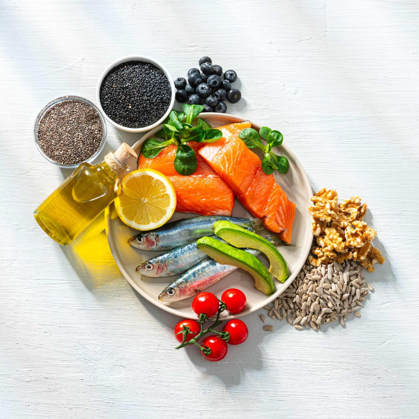 Verschiedene gesunde Lebensmittel: Lachs, Zitrone, Tomaten und mehr
