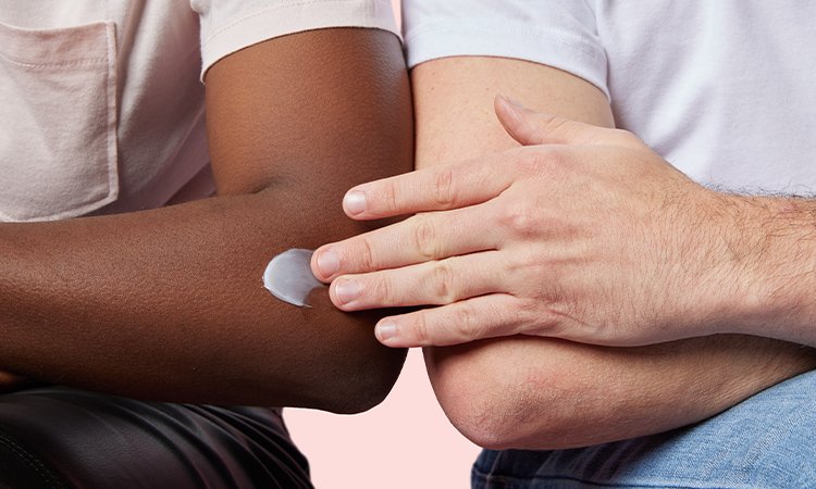 Zwei Armbeugen, auf einer wird eine Creme verteilt