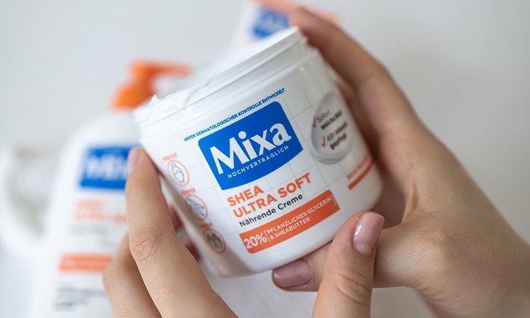 Eine Packung MIXA Shea Ultra Soft von einer Hand gehalten
