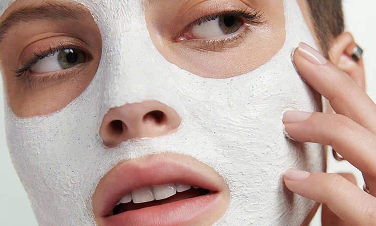 Eine Person, die eine Gesichtsmaske einwirken lässt