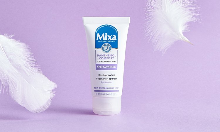 Produktabbildung von MIXA Panthenol Comfort Creme daneben schweben zwei Federn in der Luft.