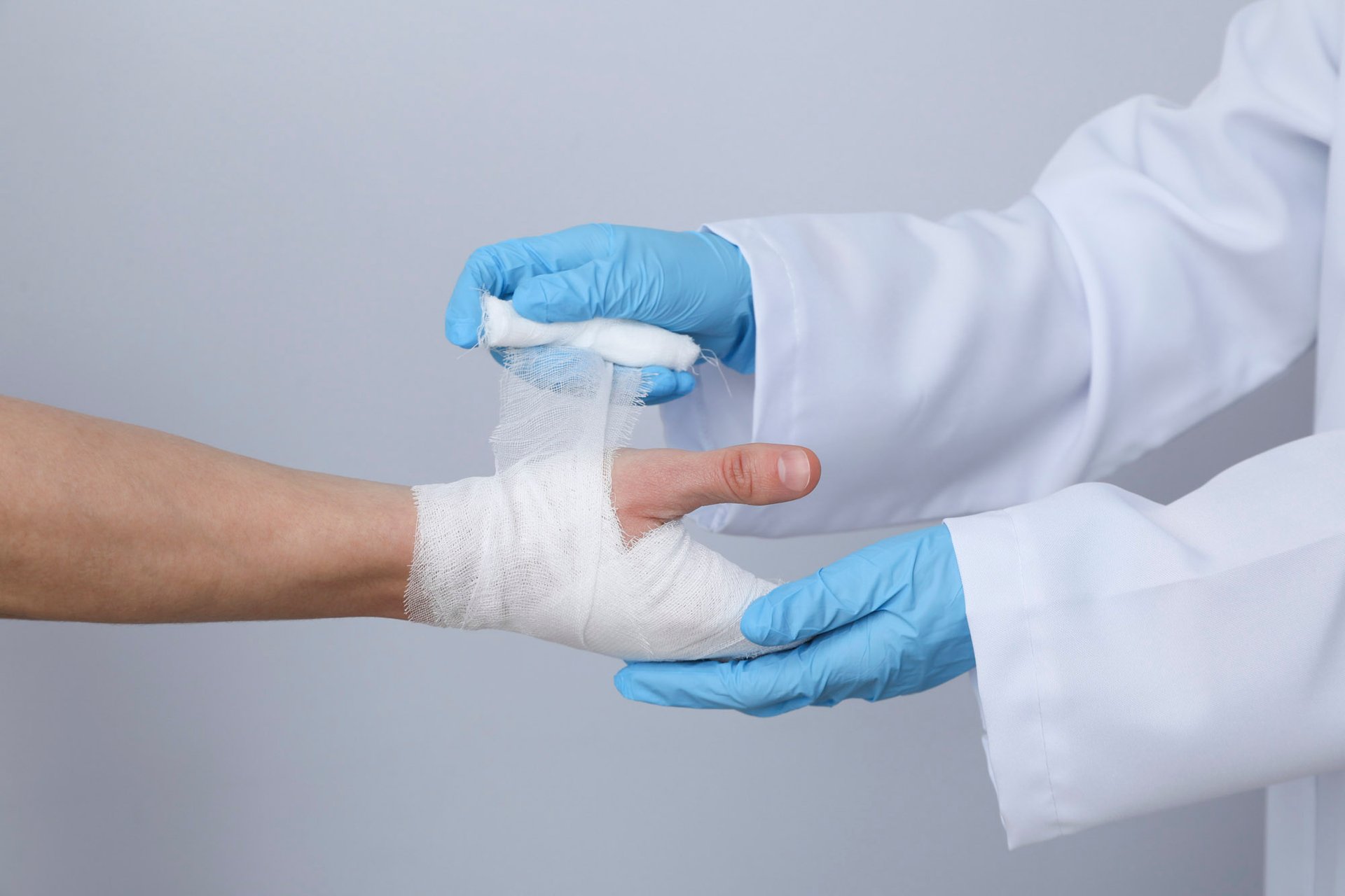 Arzt verbindet die Hand eines Patienten