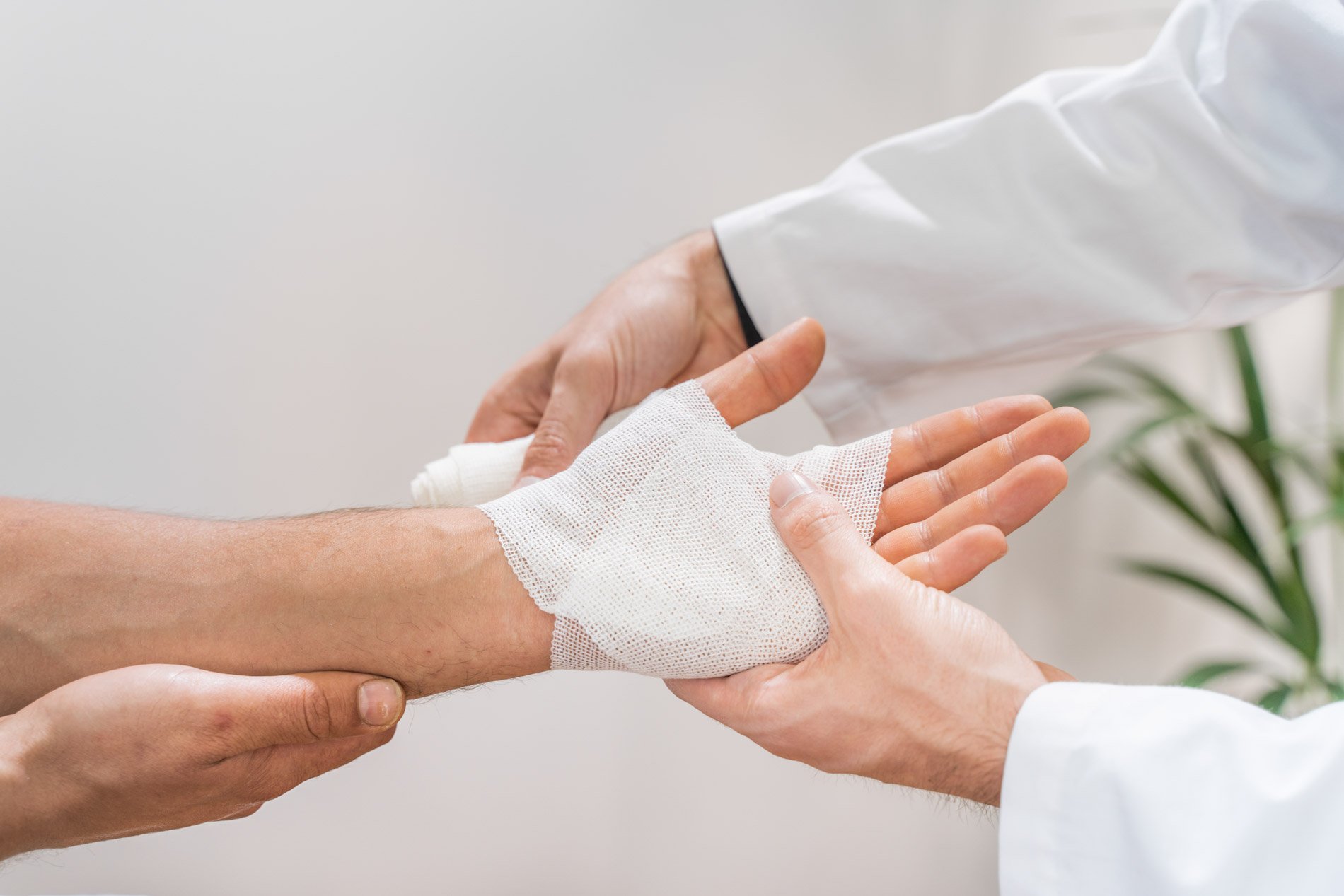 Arzt verbindet die Hand eines Patienten