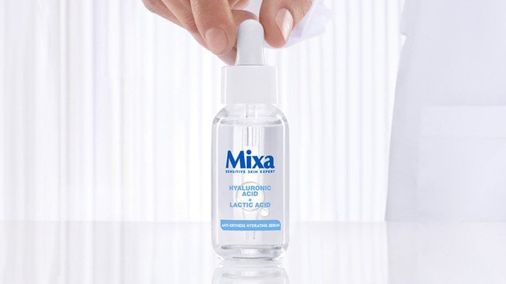 Das Mixa Serum mit Hyaluronsäure wird von einer Hand von oben gegriffen